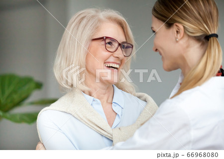 Beautiful happy aged woman embracing young adult daughter and la Beautiful happy aged woman embracing young adult daughter and la 66968080