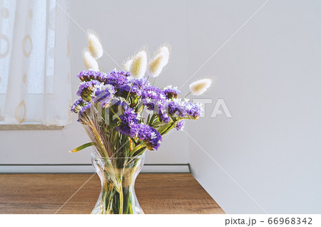 Glass vase with blue wild flowers on wooden table 66968342