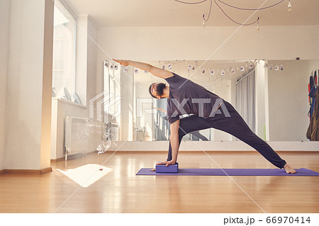 Athletic young man doing exercise with yoga blocks 66970414