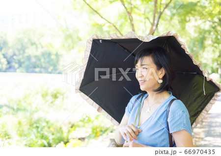 日傘を差して散歩するミドル女性  日傘が似合うミドル女性 66970435