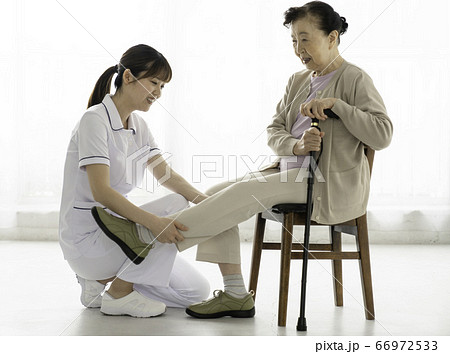 リハビリを介助する介護士 66972533