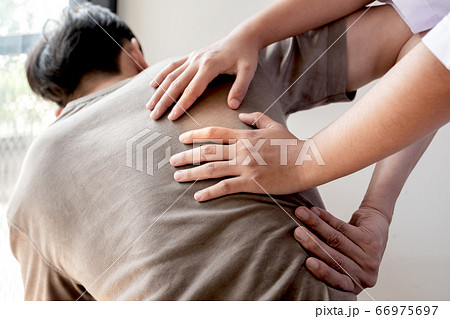 Female physiotherapists provide physical assistance to male patients with back injuries back massages for relaxation and muscle recovery in the rehabilitation center Female physiotherapists provide physical assistance to male patients with back injuries back massages for relaxation and muscle recovery in the rehabilitation center 66975697