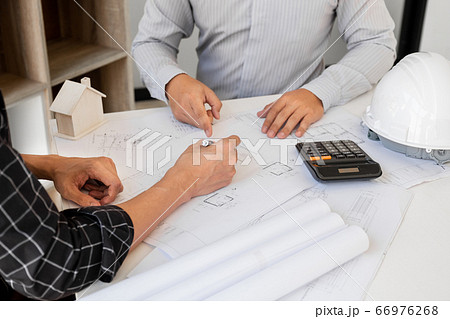 A team of confident architects working together in the office talking about construction and home design projects 66976268