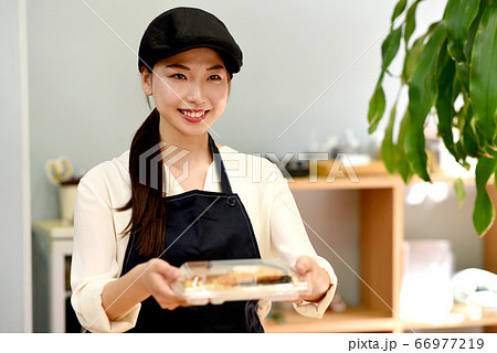 お弁当を渡す女性店員 お弁当を渡す女性店員 66977219