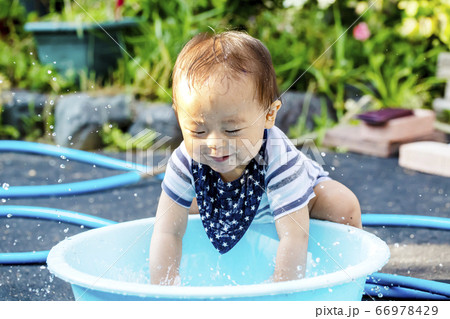 外で水色のタライで水遊びして大はしゃぎしている子供 ずぶ濡れの子供 外で水色のタライで水遊びして大はしゃぎしている子供 ずぶ濡れの子供 66978429