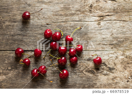 Ripe fresh sweet cherry lies on a wooden rustic table. Healthy sweet dessert Ripe fresh sweet cherry lies on a wooden rustic table. Healthy sweet dessert 66978519