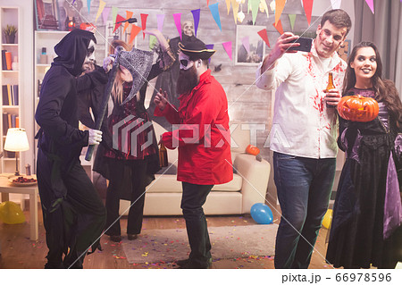 Beautiful witch holding a pumpkin at halloween party Beautiful witch holding a pumpkin at halloween party 66978596