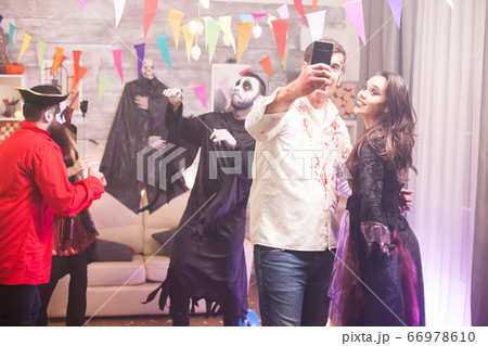Cheerful man and woman dressed up like a witch and zombie Cheerful man and woman dressed up like a witch and zombie 66978610