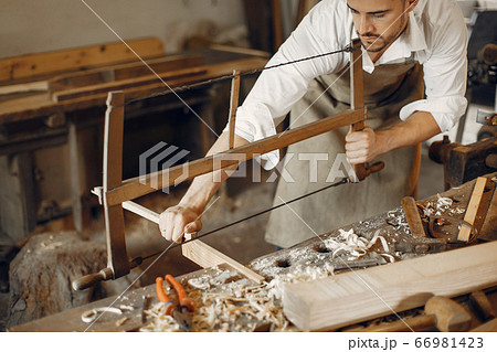 Handsome carpenter working with a wood Handsome carpenter working with a wood 66981423