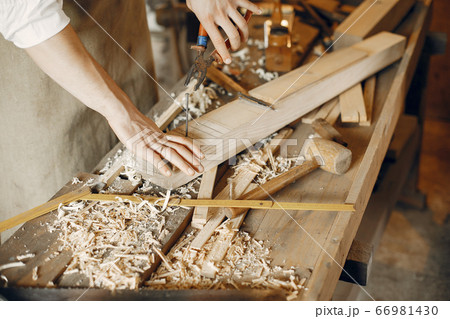 Handsome carpenter working with a wood Handsome carpenter working with a wood 66981430