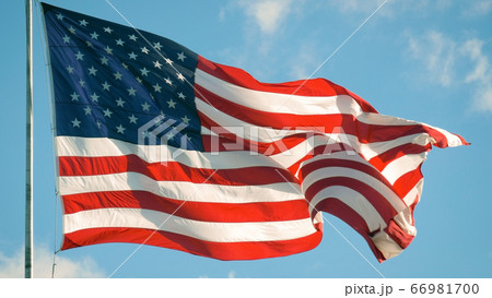 American flag flies in the sky with clouds, USA. 66981700