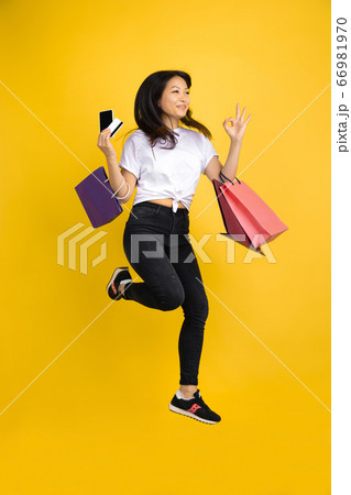 Portrait of young asian woman isolated on yellow studio background Portrait of young asian woman isolated on yellow studio background 66981970