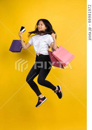 Portrait of young asian woman isolated on yellow studio background Portrait of young asian woman isolated on yellow studio background 66981972