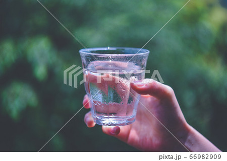 水の入ったグラスを持つ女性の手 66982909
