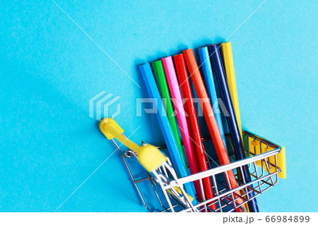 shopping cart with colored pencils on a blue background shopping cart with colored pencils on a blue background 66984899