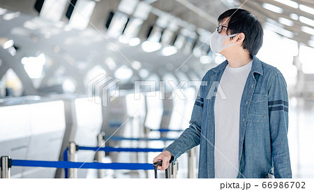Asian man tourist wearing mask in airport terminal Asian man tourist wearing mask in airport terminal 66986702