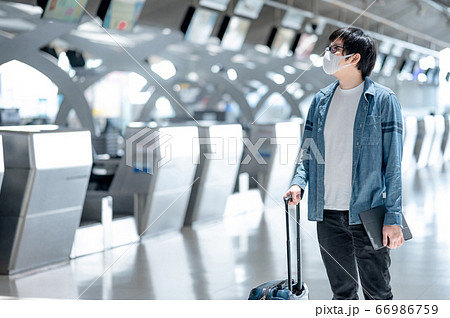 Asian man tourist wearing mask in airport terminal Asian man tourist wearing mask in airport terminal 66986759