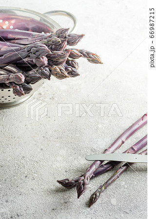 Bunch of raw organic asparagus on a board and in a Bunch of raw organic asparagus on a board and in a 66987215