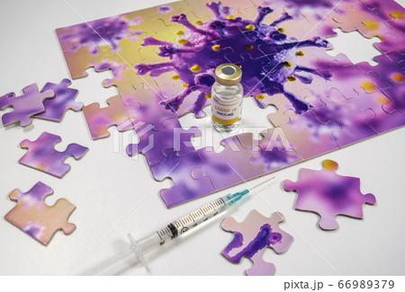Studio shot of puzzle with Coronavirus model and vaccine vials and syringe Studio shot of puzzle with Coronavirus model and vaccine vials and syringe 66989379