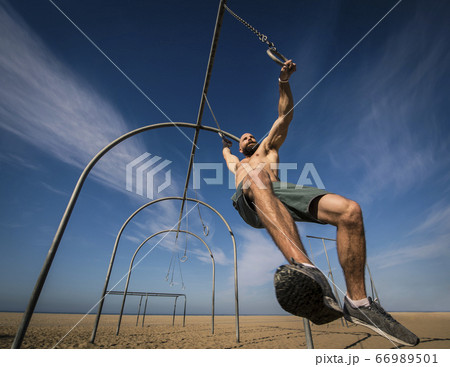 Man exercising on gymnastics rings Man exercising on gymnastics rings 66989501