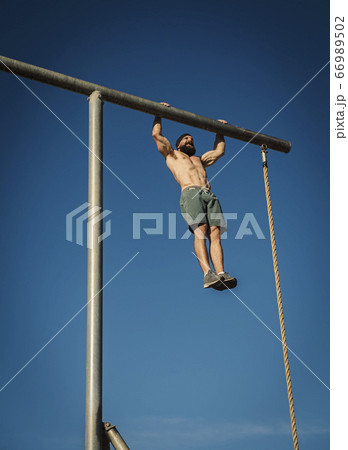 Man exercising on gymnastics bar Man exercising on gymnastics bar 66989502