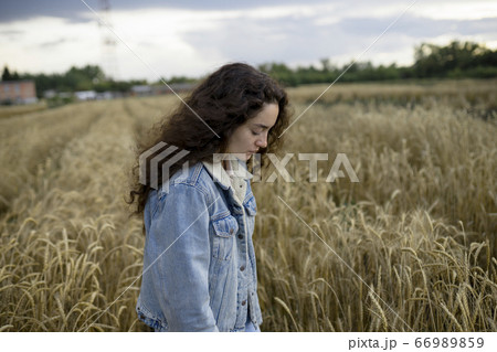 Russia, Omsk, Young woman standing in wheat field Russia, Omsk, Young woman standing in wheat field 66989859