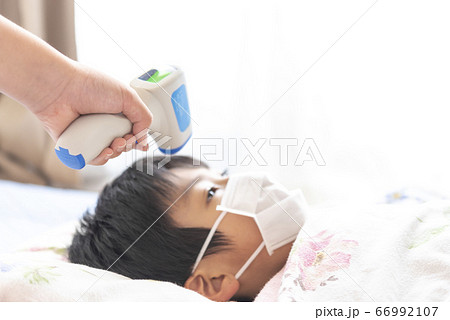 非接触式体温計で検温される男の子 66992107