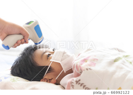 非接触式体温計で検温される男の子 66992122