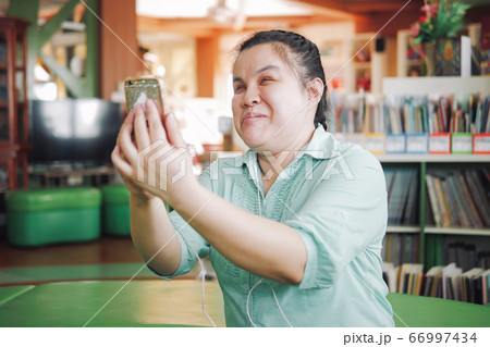 Asian young blind woman taking selfie using smart phone 66997434