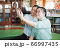 Asian young blind woman taking selfie with senior colleague 66997435