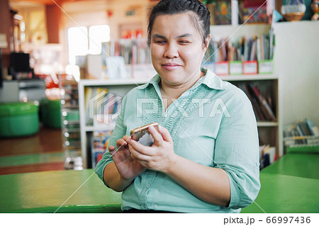 Asian young blind woman using smart phone Asian young blind woman using smart phone 66997436