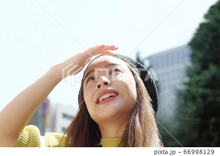 まぶしそうに上を見る若い女性 まぶしそうに上を見る若い女性 66998129