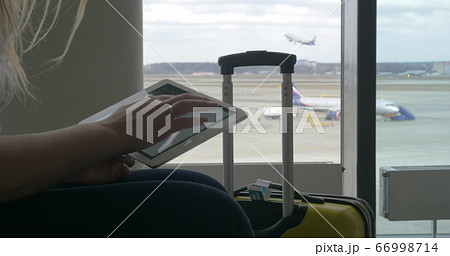 Woman waiting for the flight with tablet PC Woman waiting for the flight with tablet PC 66998714