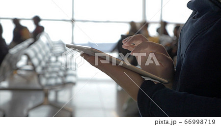 Walking with tablet computer in airport lounge Walking with tablet computer in airport lounge 66998719