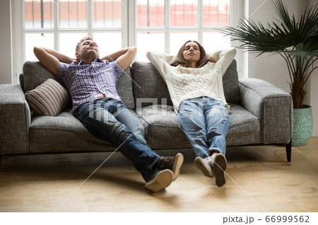 Young couple relaxing together on sofa enjoying nap breathing ai 66999562