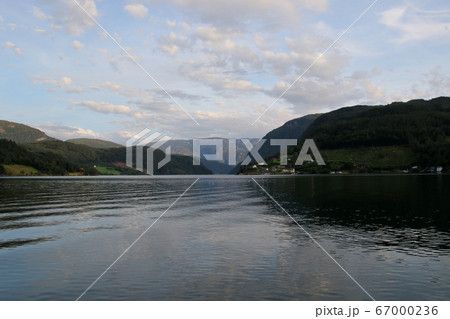 ノルウェー　ハダンゲルフィヨルド、ウルヴィク地区の南側に凪いだフィヨルドを望む　空はまだ明るい 67000236