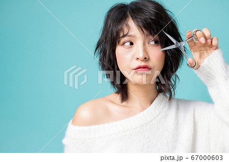 若い 美人 女性 前髪 髪型 ハサミ 切る イメージ 素材の写真素材