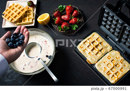 Chef adding fruit in waffles dough 67000991