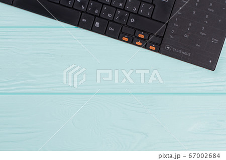 Modern computer keyboard on light blue background. 67002684