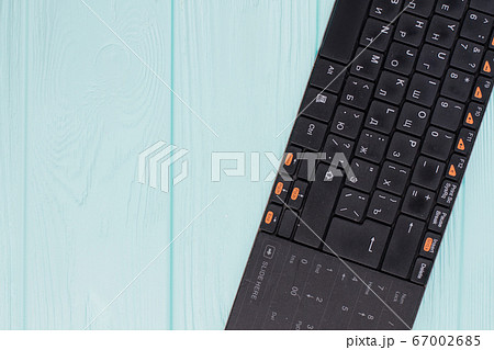 Black computer keyboard on light blue background. 67002685