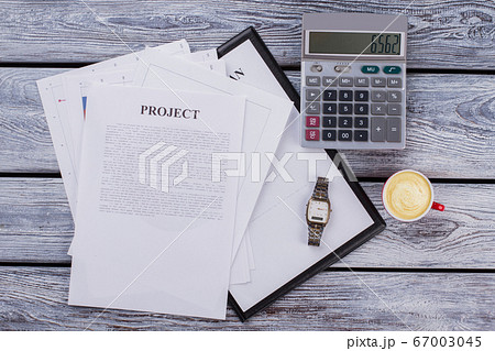 Business project paperwork with calculator and cup of coffee. Business project paperwork with calculator and cup of coffee. 67003045