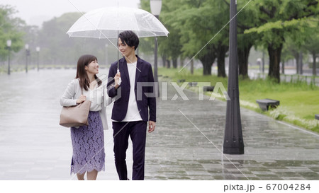 雨の日に傘を差してデートするカップル 67004284