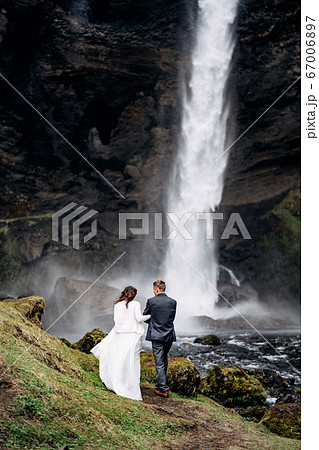 Destination Iceland wedding, near Kvernufoss waterfall. Wedding couple goes to the waterfall. Destination Iceland wedding, near Kvernufoss waterfall. Wedding couple goes to the waterfall. 67006897