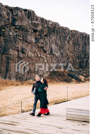 A guy and a girl are walking down the road in the Silfra Fault, in the Tingvedlir Valley. A guy and a girl are walking down the road in the Silfra Fault, in the Tingvedlir Valley. 67008325