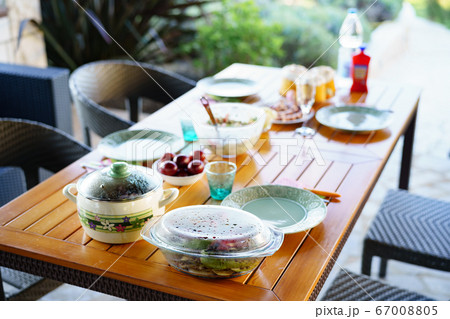 Serving table for a family dinner in the garden. Grilled vegetables, kebabs and salads on the table. Serving table for a family dinner in the garden. Grilled vegetables, kebabs and salads on the table. 67008805