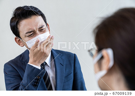 会話中に咳をするビジネスマン 67009139