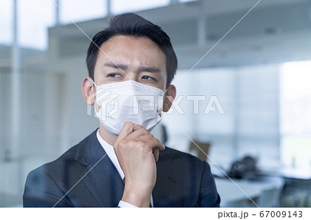 深刻そうに考えるマスクを着用したビジネスマン 新型コロナウイルス 経営危機 感染対策 深刻そうに考えるマスクを着用したビジネスマン 新型コロナウイルス 経営危機 感染対策 67009143