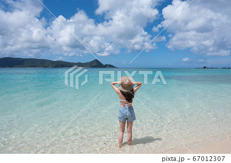 南国の海と麦わら帽子の女性の後ろ姿イメージ 撮影地 奄美大島 の写真素材