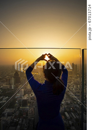 woman standing on high building roof and making 67013714