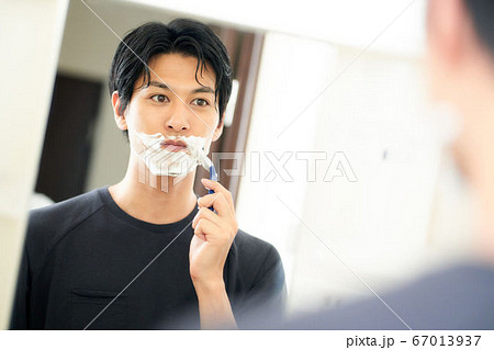 鏡の前で髭を剃る若い男性 鏡の前で髭を剃る若い男性 67013937